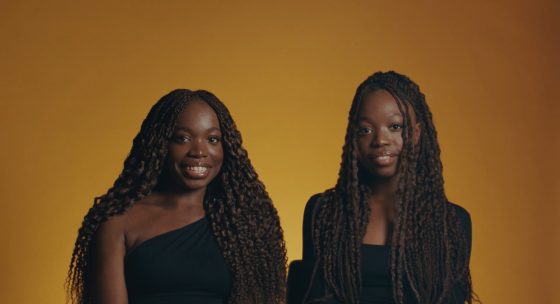 Zwei Protagonistinnen des Films NOCH LANGE KEINE LIPIZZANER vor einem orangen Hintergrund.