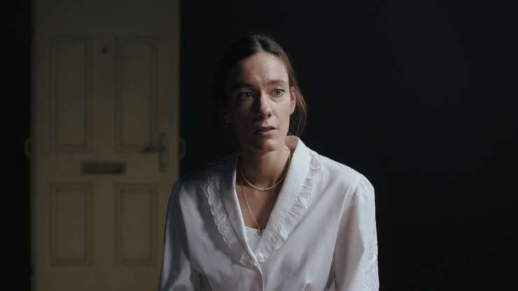 Toxische Pommes mit weißer Bluse vor schwarzem Hintegrund.