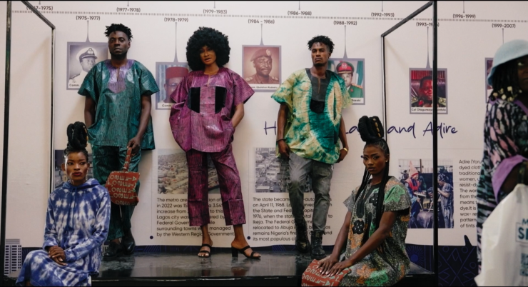 Still aus dem Film STOFF. Fünf Personen präsentieren bunte Kleidung.