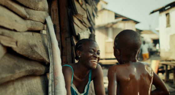 Eine Frau lächelt, ein Kind blickt zu ihr.