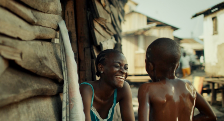 Eine Frau lächelt, ein Kind blickt zu ihr.
