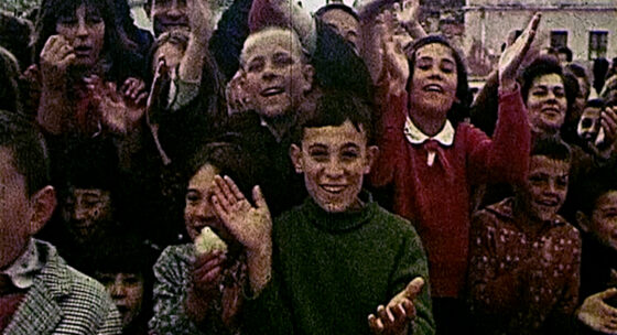 Gruppe von Menschen mit erhobenen Händen in einer Außenumgebung vor Gebäuden