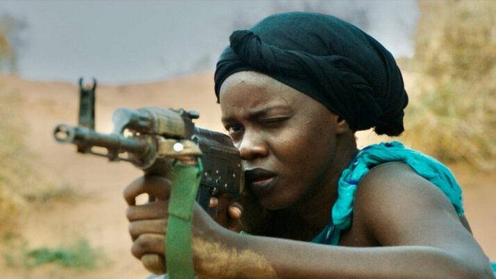 Person mit Turban hält ein Gewehr im Anschlag