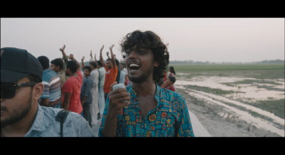 Gruppe von Menschen auf einem offenen Fahrzeug mit ländlicher Landschaft im Hintergrund