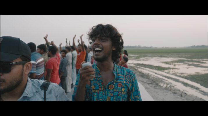 Gruppe von Menschen auf einem offenen Fahrzeug mit ländlicher Landschaft im Hintergrund