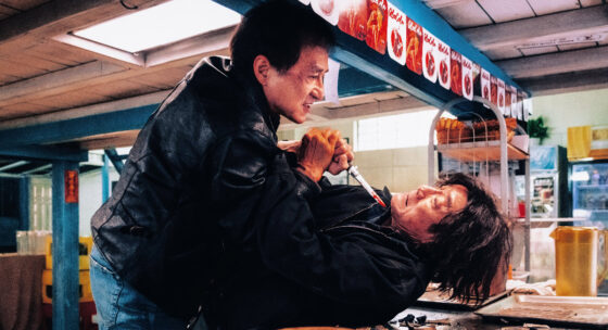 Zwei Männer in einem Raum, einer hält ein Messer an den Hals des anderen, der am Boden liegt